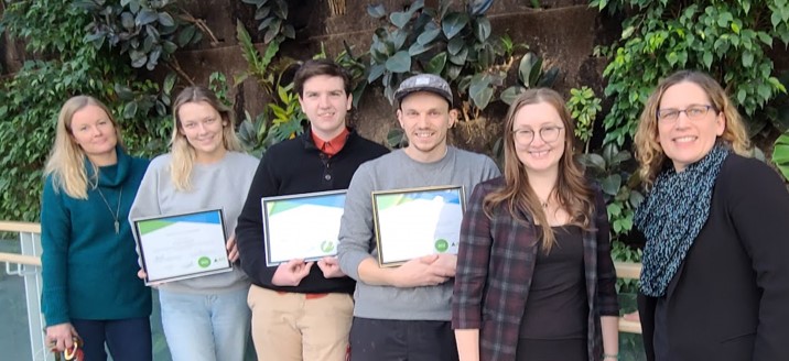 A group of people standing in a row with some holding certificates