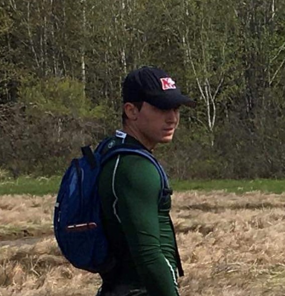 Catlin wearing a green top and backpack in a wetlands