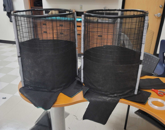 Black mesh & wire round cages on a desk after being built.