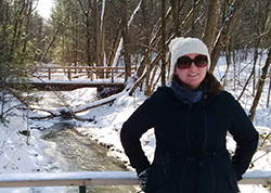 Sarah standing next to a winter stream