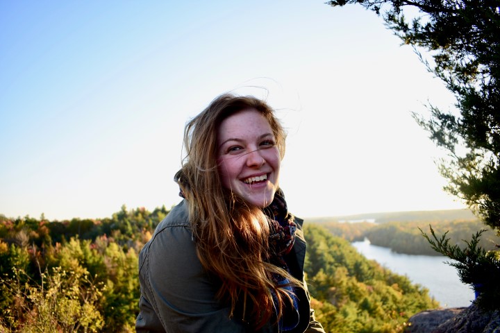 Anabelle outside at a look-out with fall tree leaf colours in distance